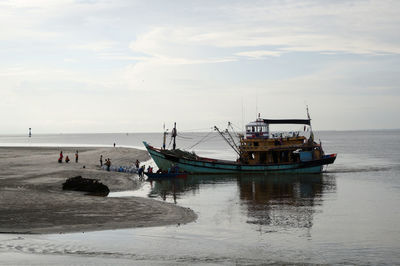 Boat moored on sea against sky