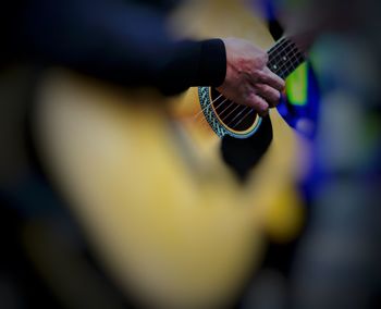 Close-up of man playing guitar