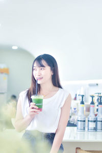 Portrait of young woman drinking wine at home