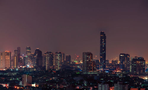 Illuminated buildings against sky at night