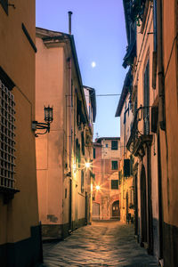 Narrow street amidst buildings in city at night