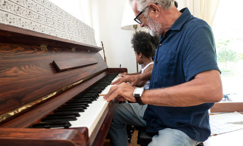 Side view of a man playing piano