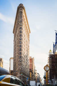 New york street activity during the day by beautiful clear blue sky at the flatiron building, nyc