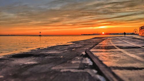 Scenic view of lake against orange sky during sunrise