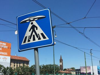 Low angle view of road sign against blue sky