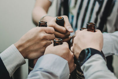 Cropped image of people toasting bottles