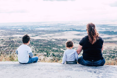 Rear view of friends sitting on looking at view