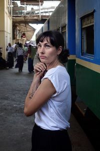 Woman looking away while standing at railway station platform