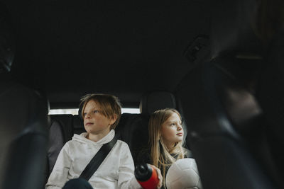 Boy and girl day dreaming about life goals while sitting in car