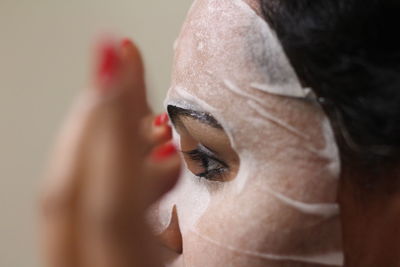 Close-up of woman using facial mask at home