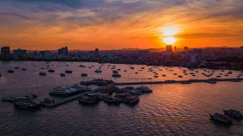 Scenic view of sea and buildings against sky during sunset