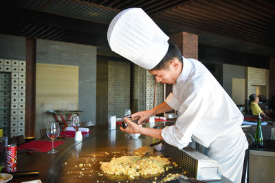 Side view of man preparing food in restaurant