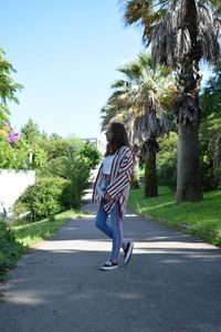 Rear view of woman walking on road