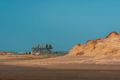 Scenic view of desert against clear blue sky