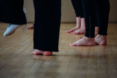 Low section of women standing on hardwood floor