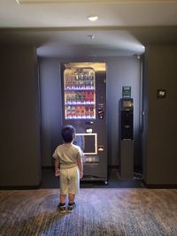 Rear view of man standing by door