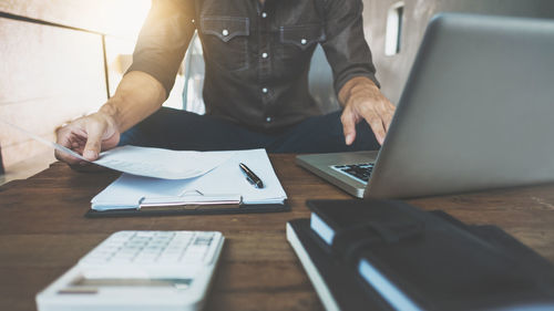 Midsection of man working on table