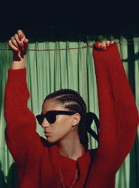 Low angle view of young woman wearing sunglasses while standing at home