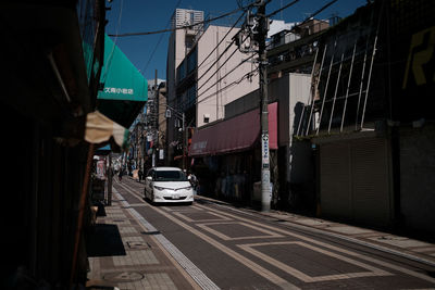 Cars on city street against sky