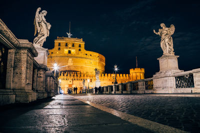 Statue in city at night