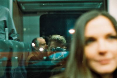 Close-up of reflection of woman on illuminated mirror