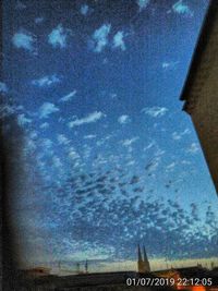 Low angle view of sky seen through wet glass window
