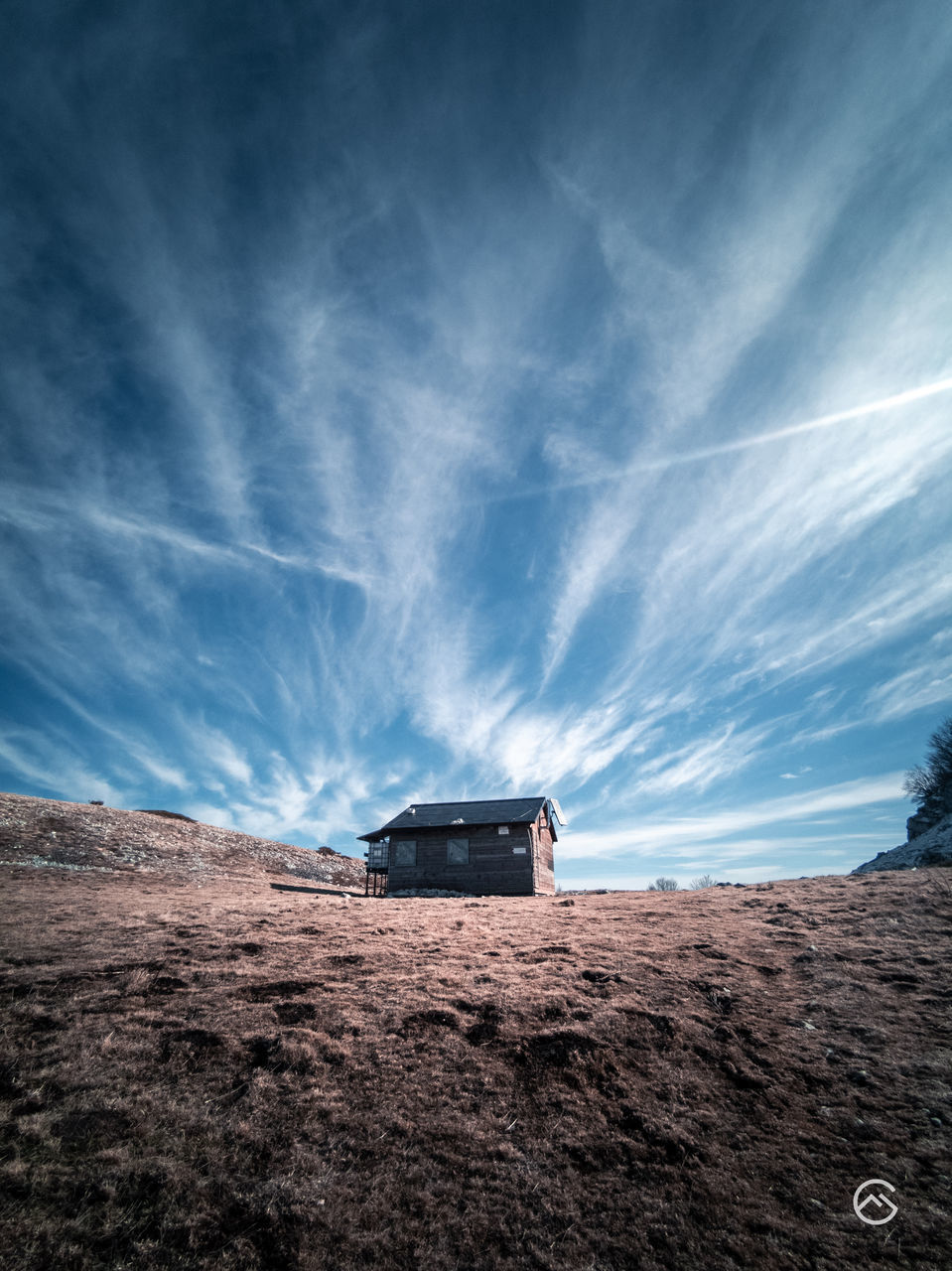 HOUSE ON ROAD AMIDST LAND AGAINST SKY