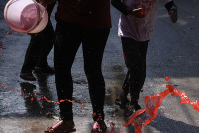 Low section of people playing holi on street