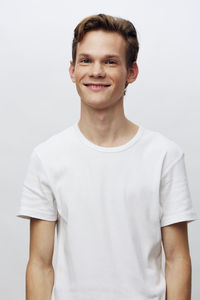 Portrait of young man standing against white background