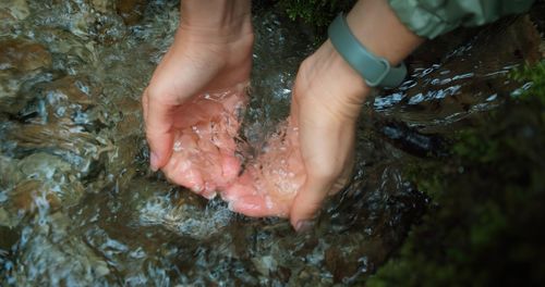 Cropped hand of woman in water