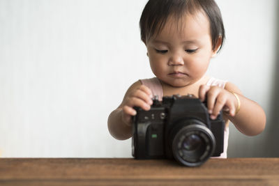 Close-up of baby girl playing with camera