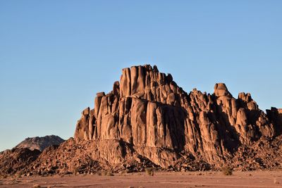 Rock formations on landscape against clear sky