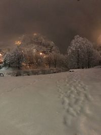 Snow covered landscape against sky at night