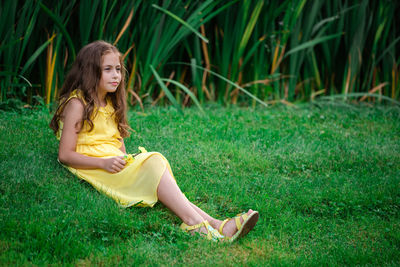 Full length of woman sitting on grass