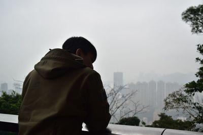 Rear view of man looking at city in winter