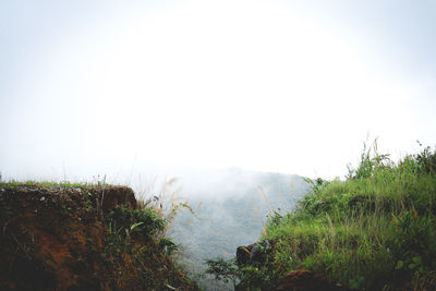 Scenic view of land against sky during foggy weather