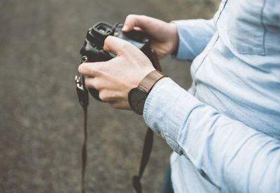Close-up of man with camera in hands