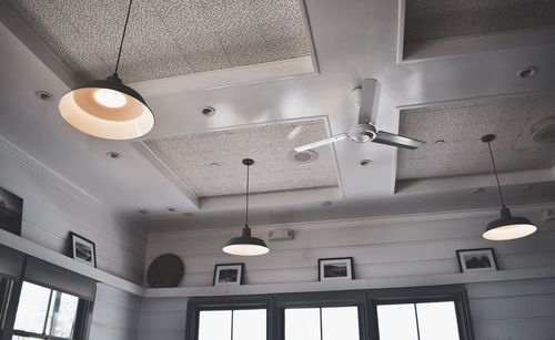 Low angle view of illuminated pendant lights hanging from ceiling