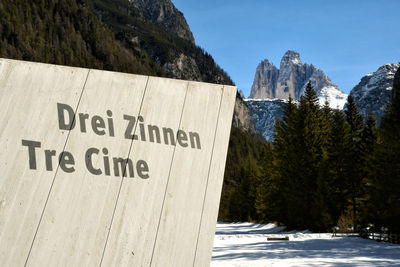 Text on snow covered mountain against sky