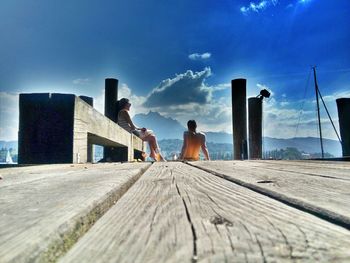 Pier on sea against cloudy sky