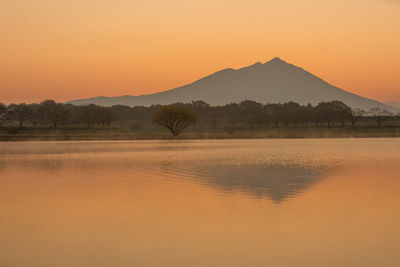 Scenic view of lake against orange sky