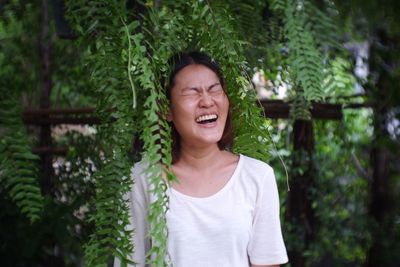 Mid adult woman standing against trees