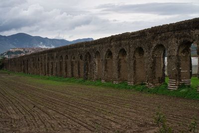 Built structure on field against sky