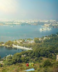 High angle view of lake and cityscape against sky