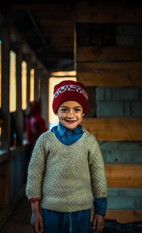 Portrait of smiling boy standing against wall