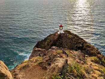 High angle view of rocks on cliff by sea