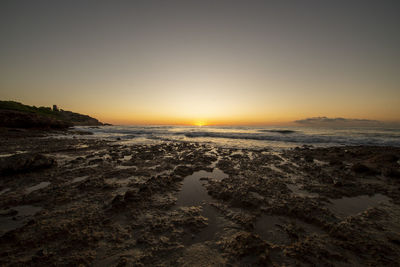 Scenic view of beach against sky during sunset