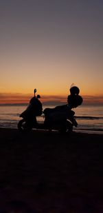 Silhouette people on beach against sky during sunset