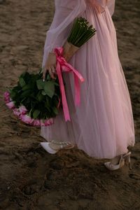 Low section of woman standing on field