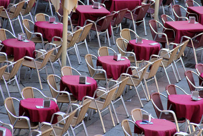 High angle view of empty chairs and tables at sidewalk cafe